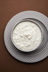 Plain curd or yogurt or Dahi in Hindi, served in a bowl over moody background. Selective focus