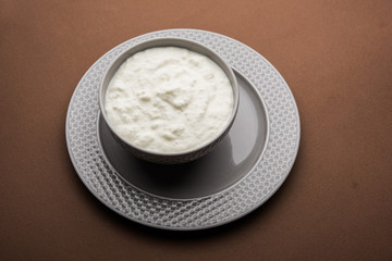 Plain curd or yogurt or Dahi in Hindi, served in a bowl over moody background. Selective focus