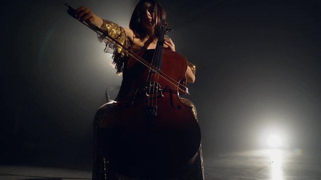 The cellist performs on stage.