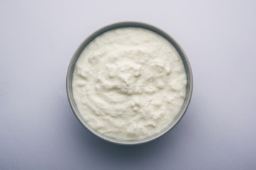 Plain curd or yogurt or Dahi in Hindi, served in a bowl over moody background. Selective focus
