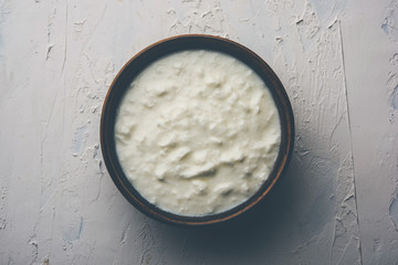 Plain curd or yogurt or Dahi in Hindi, served in a bowl over moody background. Selective focus