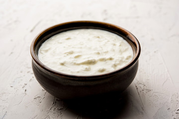Plain curd or yogurt or Dahi in Hindi, served in a bowl over moody background. Selective focus