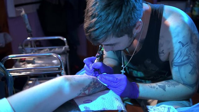 tattoo artist works with the client