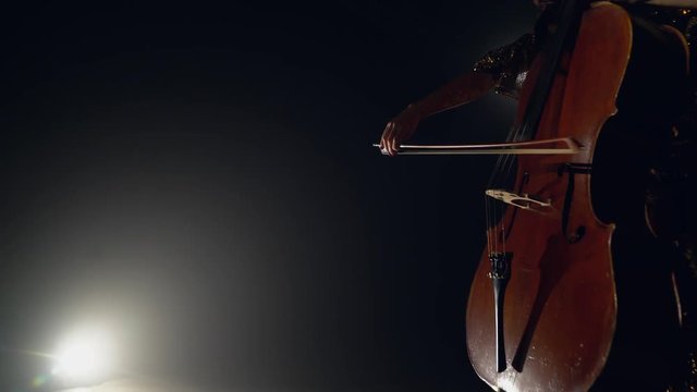 The cellist performs on stage.