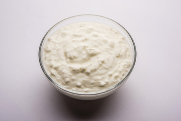 Plain curd or yogurt or Dahi in Hindi, served in a bowl over moody background. Selective focus