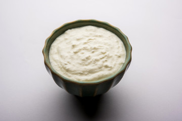 Plain curd or yogurt or Dahi in Hindi, served in a bowl over moody background. Selective focus