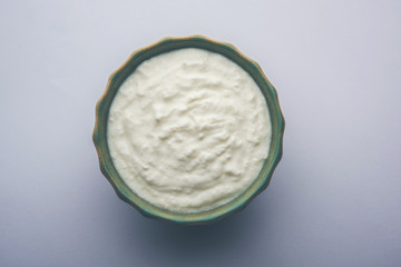 Plain curd or yogurt or Dahi in Hindi, served in a bowl over moody background. Selective focus