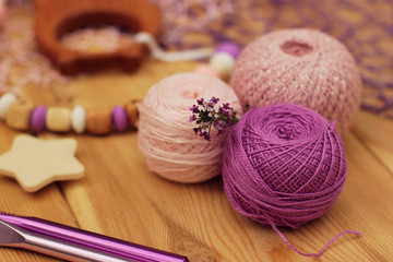 Fototapeta na wymiar pink and violet crochet yarn balls and hooks