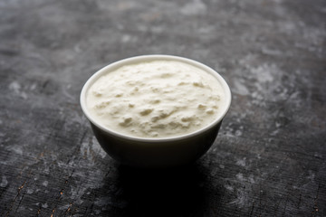 Plain curd or yogurt or Dahi in Hindi, served in a bowl over moody background. Selective focus