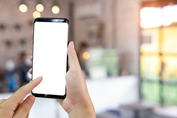 Hand using mockup smartphone in cafe.