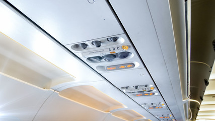 Closeup image of air ventilation holes and individual lights over the passenger seat in aircraft