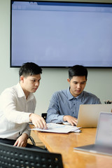 Two colleagues businessman working with computer and finance paper document.