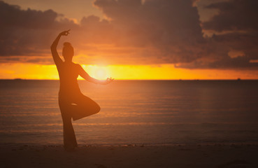 Fototapeta na wymiar Yoga on the beach Silhouette style.stance