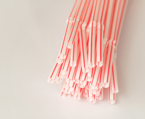 Close-up top plastic red plastic straws for drink, isolated on white background.