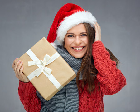 woman wearing Santa hat holding gift box.