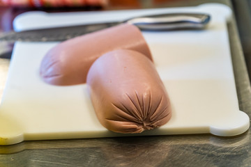 Cutted Halves of Ham, Laying on Table, with The Knife in the Background