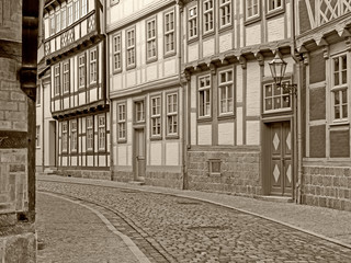 Gasse mit Fachwerkhäusern in der Altstadt von Quedlinburg in sepia