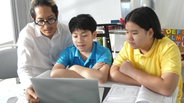 Tutor room children in class learning on laptop computer with teacher. 4K Slow motion Asian child learning with teacher at home.