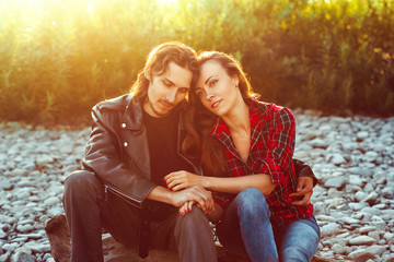 the guy with the girl sitting in the sunset
