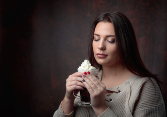 Young  beautiful woman with dark hair picked up holding a  mug  coffee with cream.