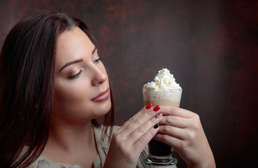 Young  beautiful woman with dark hair picked up holding a  mug  coffee with cream.