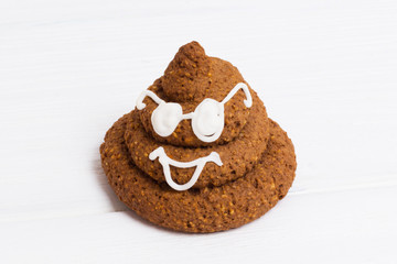Funny poop emoji chocolate cookie with white decor and glasses. Cute food dessert. Free place for text. Copyspace. Closedup