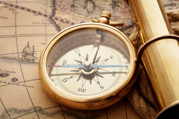 Fototapeta na wymiar compass and spyglass on old map