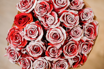 Adorable red roses decorated with white glitter sand