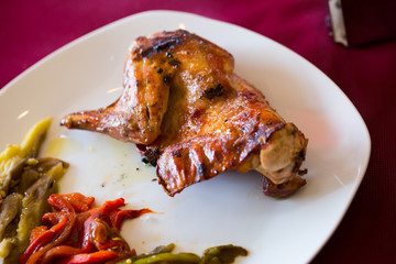 Fried rabbit, served with vegetables at plate, dish of spanish cuisine