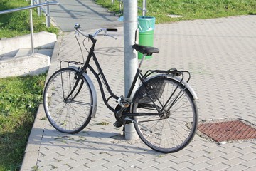 Vintage bicycle, for women. Leaning on the light pole