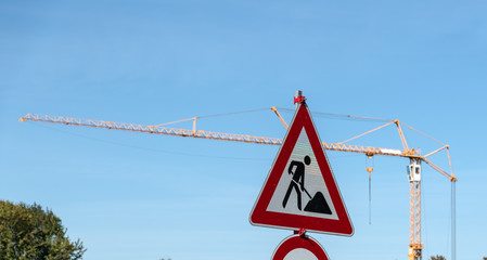 Verkehrszeichen Achtung Baustelle vor einem Kran