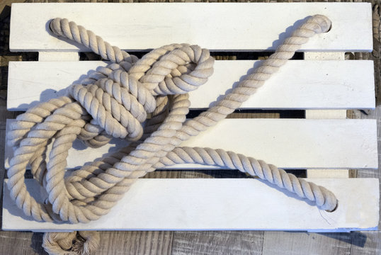 Cuerda fijada a madera que forma el asiento de un columpio para el jard&iacute;n.