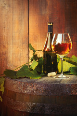 White wine bottle and glass on old barrel