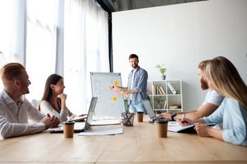 Achieving best results together. Modern young man conducting a business presentation while standing in the board room.