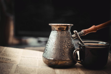 Сoffee pot and newspaper on table with the cup