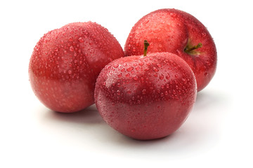 Red ripe apples with drops, isolated on white background. Fresh raw organic fruits.