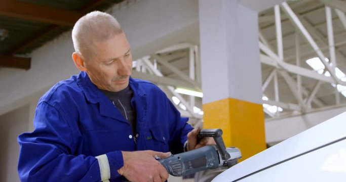 Mechanic polishing a car with grinder 4k