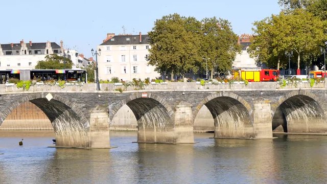 The Verdun bridge in Angers (France) is a vaulted bridge with two traffic lanes for cars. It is the oldest passage from one side of the Maine to the other. Vehicles are passing over it.