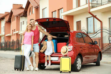 Happy family near car trunk with suitcases outdoors © New Africa