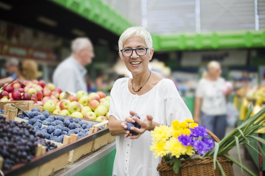 Senior woman buying fruit on market