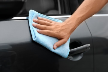 Man washing car door with rag, closeup
