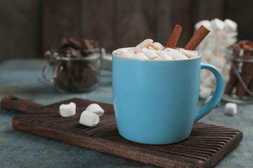 Cup of chocolate milk with marshmallows on wooden table
