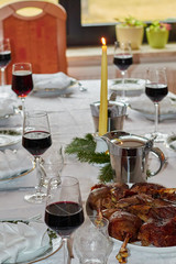 festively but natural set dining table with goose legs in the foreground