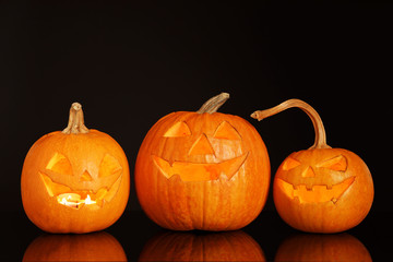 Halloween pumpkin heads. Glowing jack lanterns on dark background