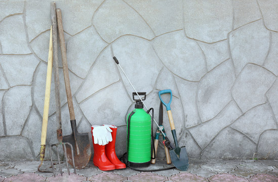 Set of gardening tools near wall outdoors. Space for text