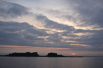Dramatic clouds over the silhouettes of uninhabited islands in the Chesapeake Bay at sunset.