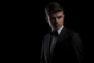 portrait of handsome young man in tuxedo looking to side