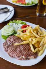 Open hamburger with french fries and salad