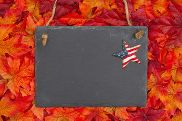 Autumn time in the USA with a chalkboard with a retro stars and strips star and fall leaves