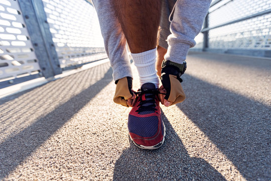 Close up image of male runner tying shoes